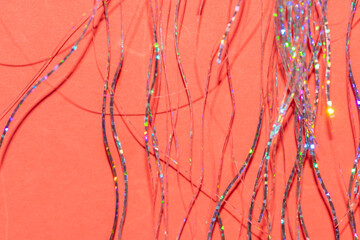 festive holographic tinsel fringe detail on coral red background