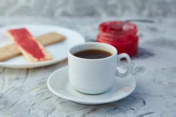 Crispbread with jam for Breakfast on a gray background. A jar of Fresh Honey with foam is next to a Cup of coffee. A minimum of calories. proper nutrition