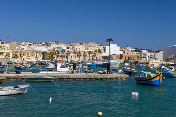 Traditional eyed colorful boats Luzzu in the Harbor of Mediterranean fishing village Marsaxlokk, Malta