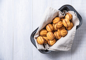 handmade nuts baked with caramel in a baking dish on a white table.
