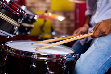 indian man playing the drums sticks close-up in recording studio