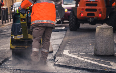 Travaux sur la chaussée: des ouvriers en train de refaire le revêtement de la route, goudron et bitume remplacés
