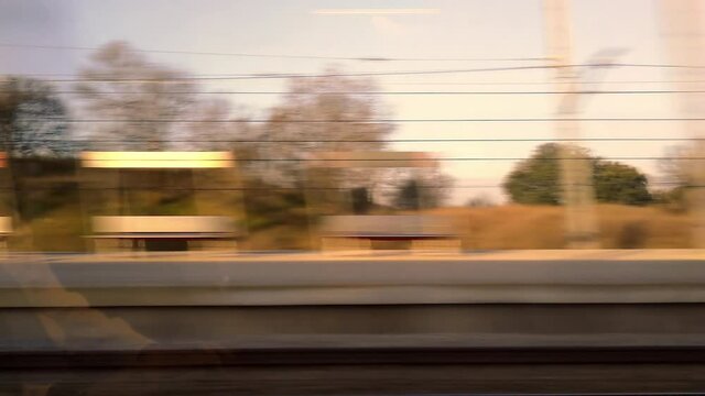 Window view of moving train with reflection of man working with laptop