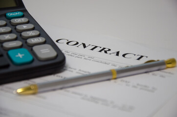 contract pen and calculator lie on a white background. sign contract.