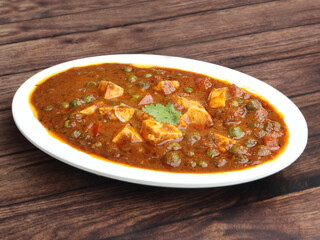 Matar Paneer masala recipe made using cottage cheese, green peas, served over a rustic wooden background, selective focus