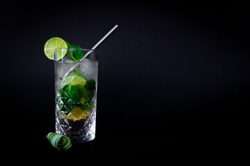 Fresh mojito cocktail with mint and lime on black background