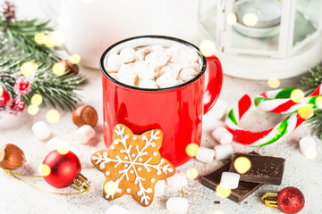 Christmas drink. Hot chocolate with marshmallow and gingerbread cookies and holiday decorations at white table.
