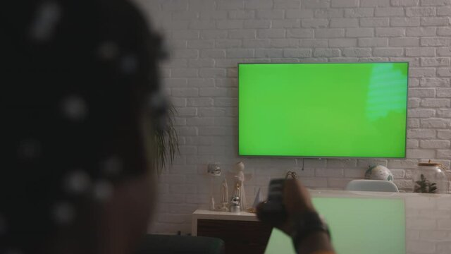 African american black man watching large green tv screen and changin the channels. High quality 4k footage