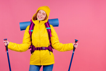 Happy woman ready for travel to mountains in new yellow jacket