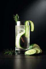 Cold refreshing drink with ice, cucumber, and rosemary.