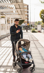 Obraz premium Bearded man with his sleeping baby on car looking phone