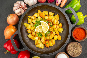 top view fried potatoes inside pan with different seasonings and vegetables on the dark background cuisine meal food color pepper
