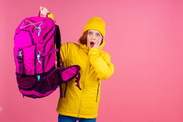 Happy woman ready for travel to mountains in new yellow jacket