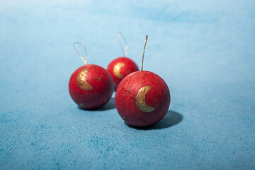 tres bolas rojas de decoración navideña sobre tela azul clara