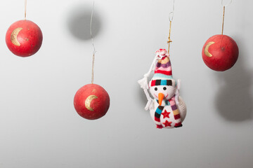 adornos de navidad con bolas de color rojo y muñeco de nieve colgando en el aire y aire minimalista