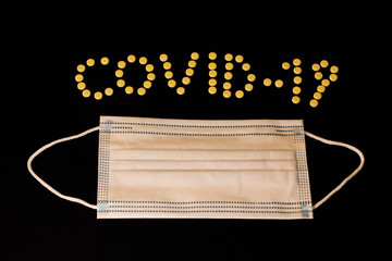 Protective mask with covid-19 drug on a black background