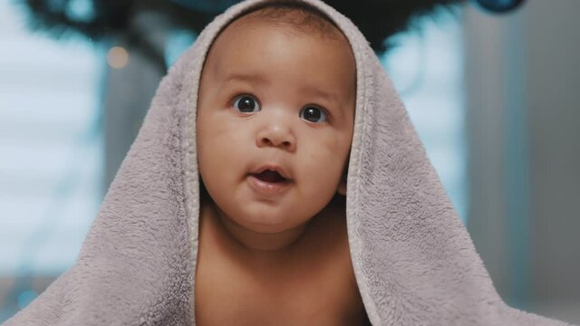 Adorable baby covered with towel having fun tummy time. High quality 4k footage