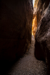 Landscape of a dry riverbed with narrow stone corridor with light