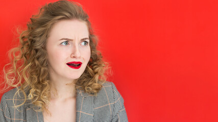 Young pretty woman with open mouth, looking horrified and shocked against red wall, web banner. Expressive facial emotions
