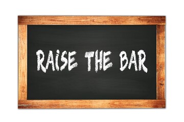 Obraz premium RAISE THE BAR text written on wooden frame school blackboard.