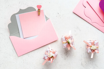 Pink envelope and gift box on white stone background. Love concept. Romantic congratulation on Valentine's Day.