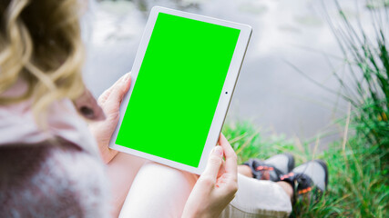 Woman holding a tablet in the park