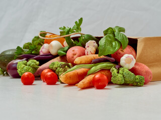 Vegetables in paper bag on white background.