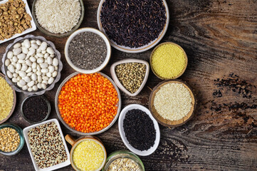 Food background of various cereals and grains in plates on a wooden table