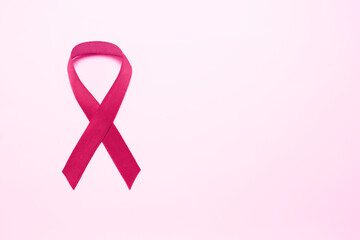 Pink ribbon on color background, top view with space for text. Breast cancer awareness concept.