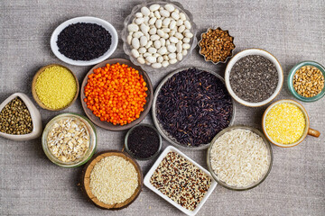 Food background of various cereals and grains in plates on a canvas