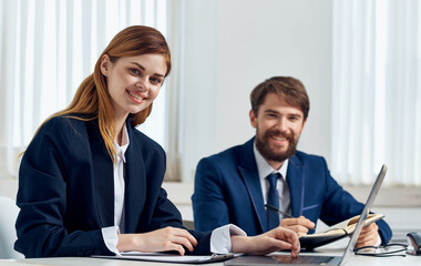 Happy Business people in the office with a laptop are sitting at the table In a bright room