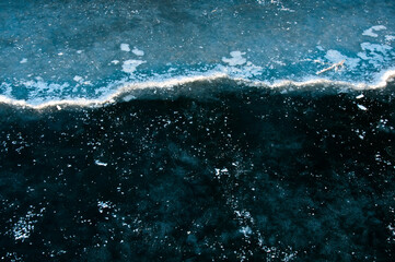 Abstract ice texture. Cracks in a piece of blue ice. Wave.