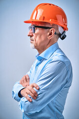 Mature architect in black glasses wearing orange helmet