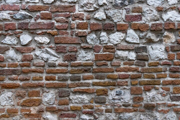 background fragment of an old ancient wall made of brick and stone