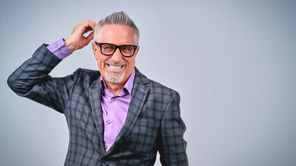 Happy stylish businessman in plaid blazer looking at camera