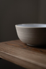 Empty ceramic bowl standing on wooden table