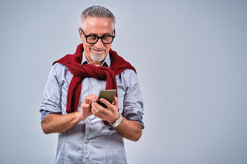 Smiling handsome adult male using mobile phone and typing