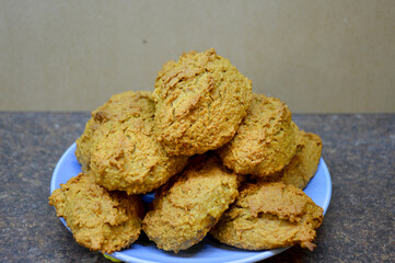 oatmeal cookies, folded in a slide on a blue plate, in the back light brown background