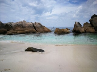 La Digue island beach with cliffs in Seychelles