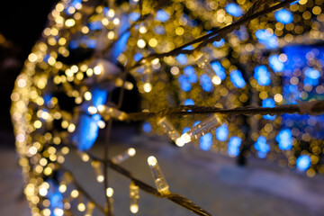 Selective focus on LED Christmas lights. Yellow lights on a blurred background. Magical New Year's lighting.