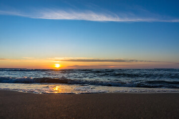 Sunset over the sea. Reflection of sunlight in the sea waves. The sky in the sunset rays. Baltic Sea.