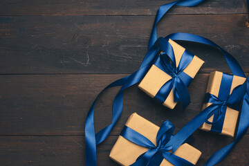 rectangular box wrapped in brown paper and tied with a blue silk ribbon with a bow