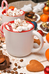 sweet food top view background for merry christmas or new year holiday decoration - chocolate candies, tangerines, cookies, marshmallow and cocoa latte on white wood