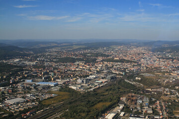 View from the plane on the city of Brno in the Czech Republic in Europe. In the background is a blue sky with white clouds.