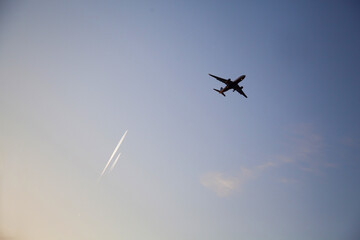 Passenger plane in the air, view from below, two planes in the distance.