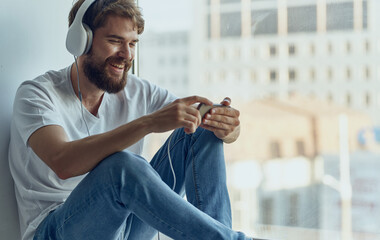 bearded man with headphones listening to music relaxing at home