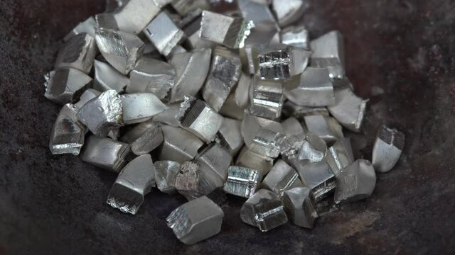 Silver particles drop into the jewelry plate for melting. Close up