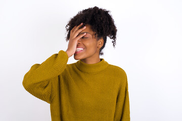 Fototapeta na wymiar Charismatic carefree joyful Young beautiful African American woman wearing knitted sweater against white likes laugh out loud not hiding emotions giggling hear funny hilarious joke chuckling facepalm.