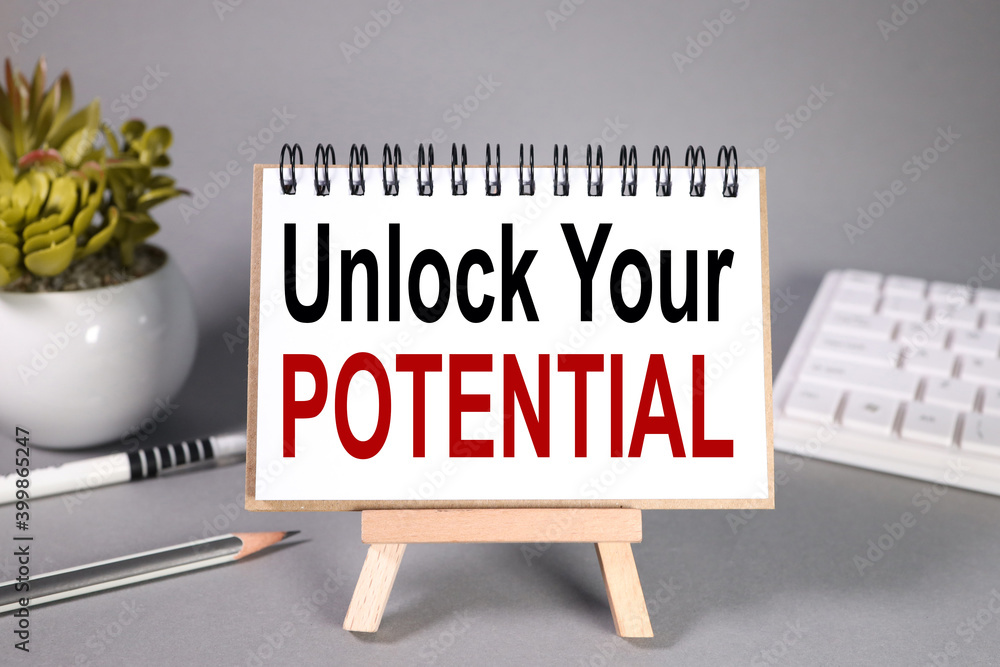 Poster unlock your potential. text on white notepad paper and backing on