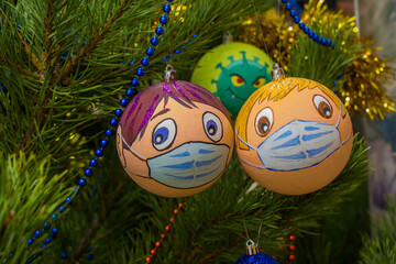 Masked gay couple, two boys. Behind them, the coronavirus, a hidden threat, sneaks up behind them. Balls for decorating the Christmas tree. Hang on a pine branch.  - obrazy, fototapety, plakaty